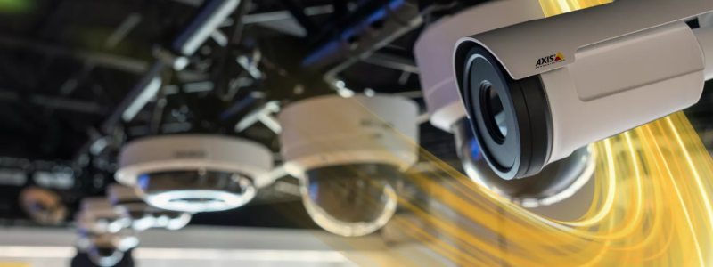 Verkada Installers Close-up of multiple security cameras mounted on a black metal frame, with yellow light trails swirling around the cameras, highlighting movement or data transmission—a nod to Jendy Physical Security and expert Verkada Installers.