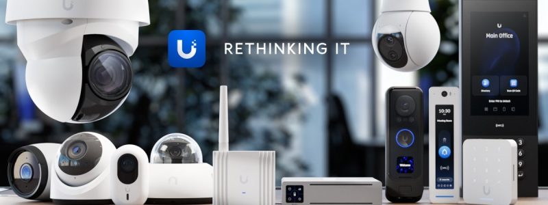 Verkada Installers A variety of Ubiquiti security cameras, smart devices, and networking equipment are displayed on a wooden surface with the Ubiquiti logo, the words Rethinking IT, and a mention of Jendy Physical Security in the background.